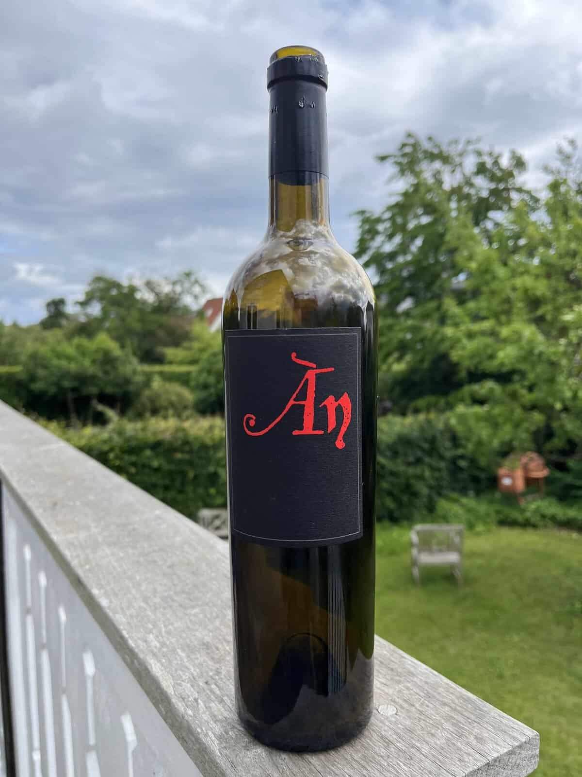Flaske rødvin med rødt 'Arp' logo på terrasse